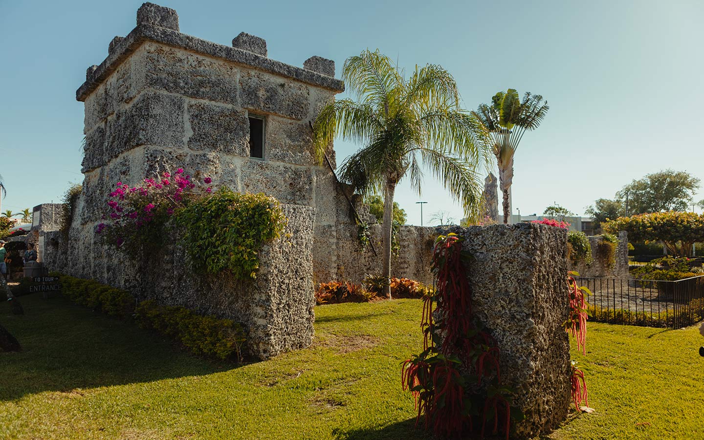 Coral Castle tower made completely out of coral rock with blue sky and palm trees