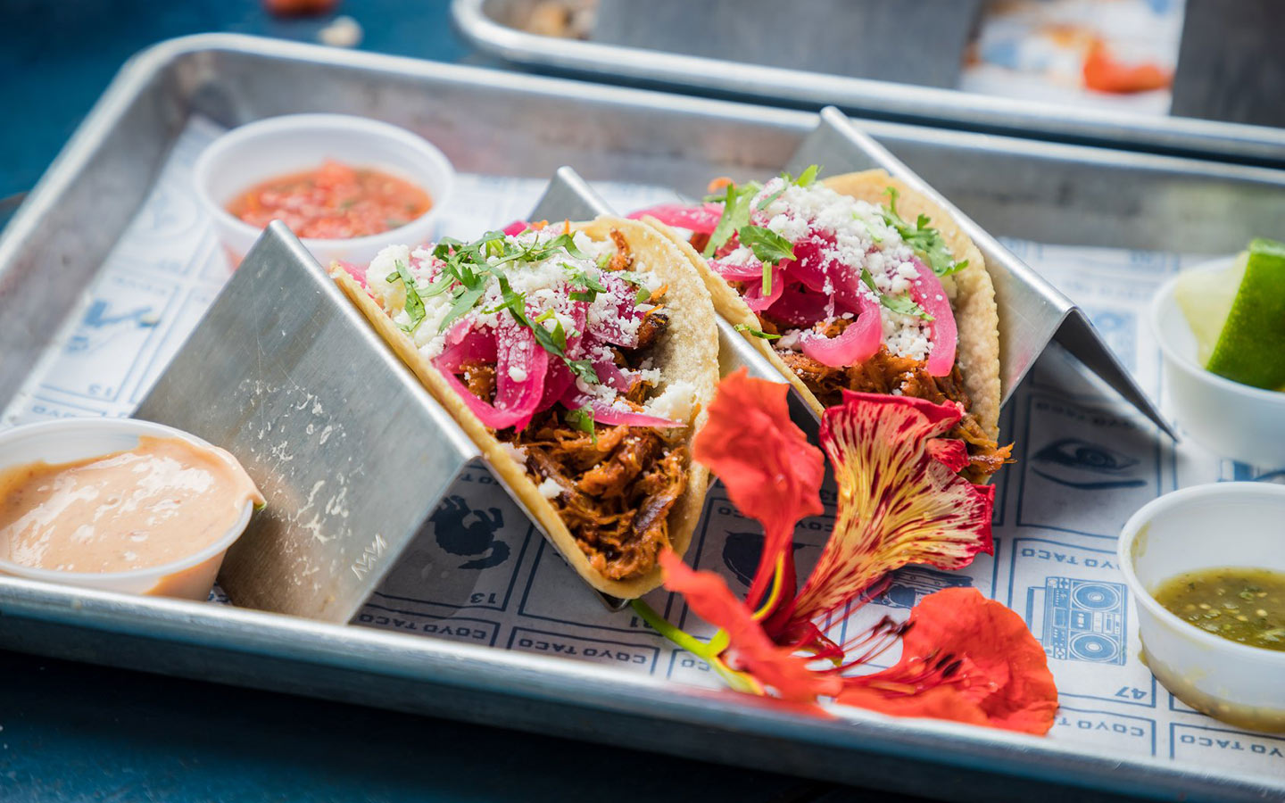 Tray with tacos and side sauces at Coyo Taco